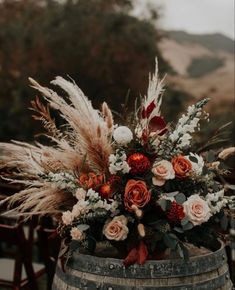 an arrangement of flowers in a wooden barrel