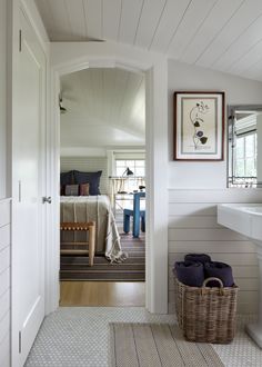 an open door leading to a bedroom with white walls and wood flooring on the other side