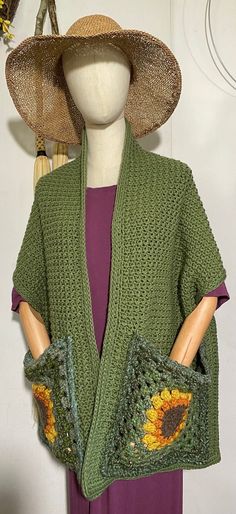 a woman wearing a green knitted cardigan with sunflowers on it