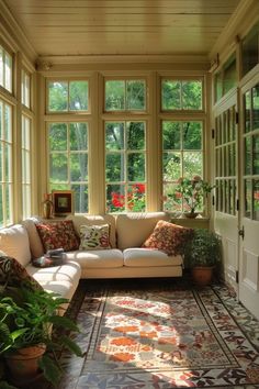 a living room with lots of windows and plants on the floor in front of it