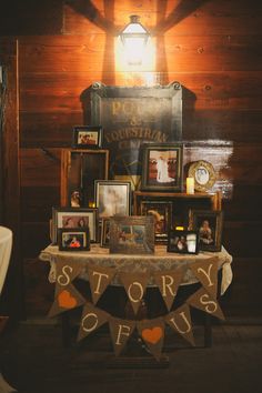 a table with pictures and other items on it in front of a wall that says story of us