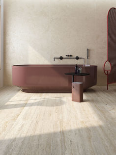 a bath tub sitting on top of a wooden floor next to a table and chair