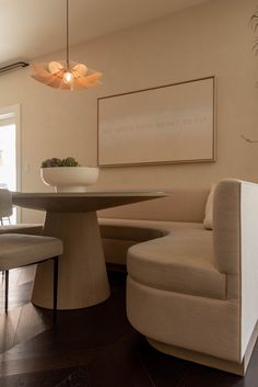 a living room with a couch, table and chairs in it's center area