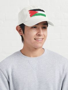 a young man wearing a hat with the flag of kuwait on it