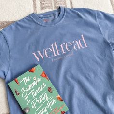 a book and t - shirt sitting on top of a bed next to each other