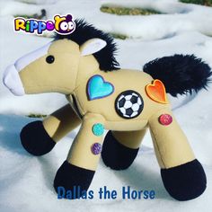 a stuffed horse is sitting in the snow and has hearts on it's tail