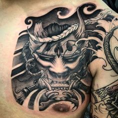 a man's chest with tattoos on it