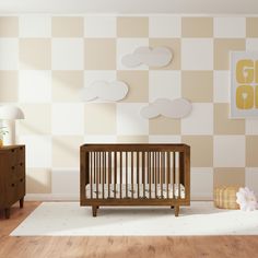 a baby's room with a wooden crib and checkered wallpaper