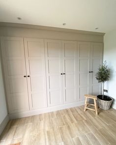 an empty room with white cupboards and a potted plant