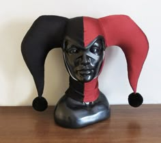 a black mannequin head with a red and black hat on it's head