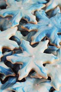 blue and white decorated cookies with frosting on them are arranged in the shape of snowflakes