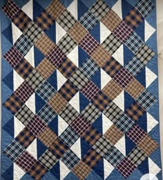 a blue and white quilt hanging on the wall