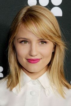 a woman with blonde hair wearing a white shirt and pink lipstick