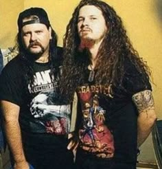 two men standing next to each other in front of a wall with the words pantera on it