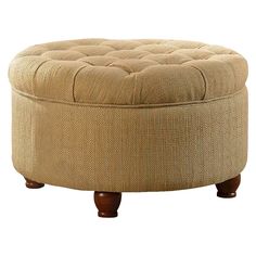 a round ottoman sitting on top of a wooden table