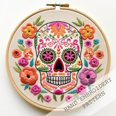 a hand embroidered sugar skull with colorful flowers on it's face is featured in this embroidery pattern