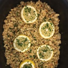 a pan filled with rice and lemons on top of a stove burner covered in seasoning