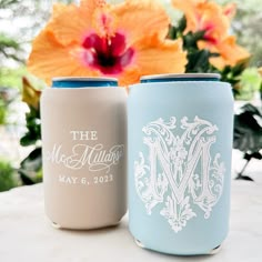 two wedding can coolers sitting next to each other on a table with flowers in the background