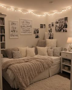 a bed with pillows and blankets on top of it next to a bookshelf