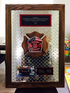 an award plaque is displayed in front of a glass display case with a flag on it