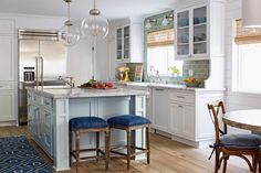 a kitchen with two blue stools in front of an island and counter top area