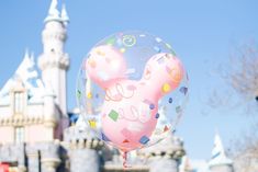 there is a balloon that has been decorated with confetti and balloons in front of the castle