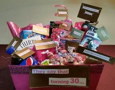 a pink box filled with lots of assorted items on top of a red table