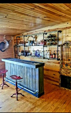 an old fashioned bar in the corner of a room with wooden walls and flooring