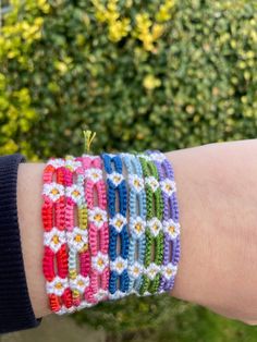 a woman's arm with several bracelets made from crocheted yarn and beads