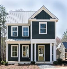 a blue house with white trim on the front and side windows is pictured in this image