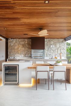 a modern kitchen with an island and built - in wine cooler