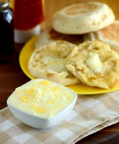 some food is on a yellow plate with a white bowl and sauce in front of it