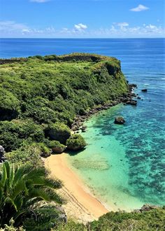 the beach is surrounded by green vegetation and blue water