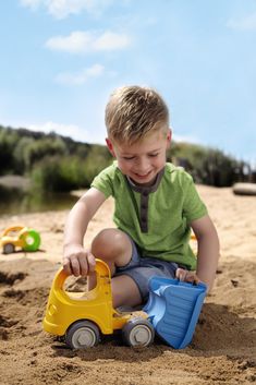 A boy is using a sand truck toy Excavator Toy, Water Play, Beach Essentials, Sand Castle, Toy Trucks