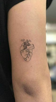 a small heart tattoo on the arm