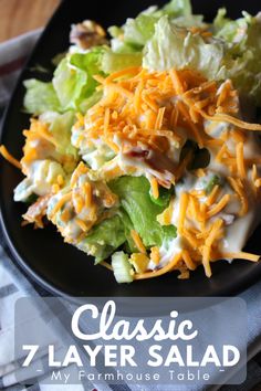 a salad with cheese and lettuce on top is shown in a black plate