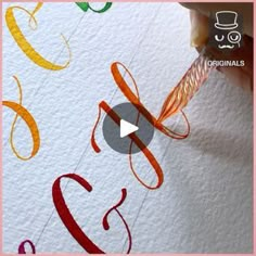 someone is drawing letters on paper with colored pencils