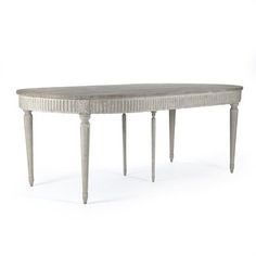 an oval dining table with legs in whitewash and grey finish, on a white background