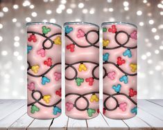 three pink candles decorated with multicolored hearts