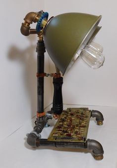 a lamp that is sitting on top of a piece of circuit board next to a pipe