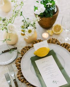 a place setting with lemons and white flowers