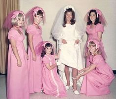 a group of women in pink dresses and veils