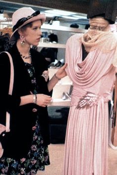 two women looking at dresses on display in a store