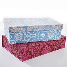 three boxes are stacked on top of each other in different colors and patterns, one is pink, the other blue