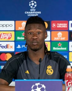 a man sitting at a table in front of a microphone with a soccer ball on it