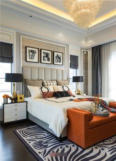 a bedroom with zebra print rugs and an orange chair in front of the bed