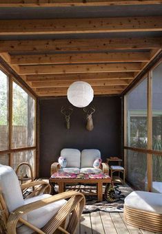 a covered porch with wicker furniture and deer heads on the wall