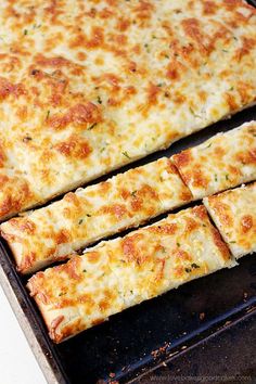 several slices of pizza sitting on top of a baking pan next to eachother