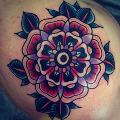 a colorful flower tattoo on the side of a woman's stomach