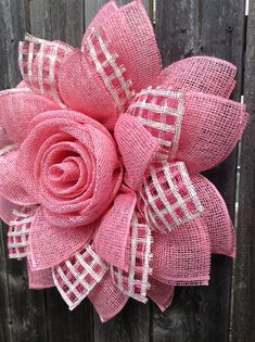 a pink flower on top of a wooden fence